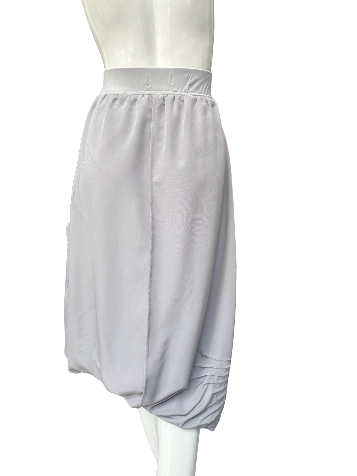 White Blaine Skirt on mannequin showing asymmetrical adjustable hemline with diagonal seam details and side pocket functionality