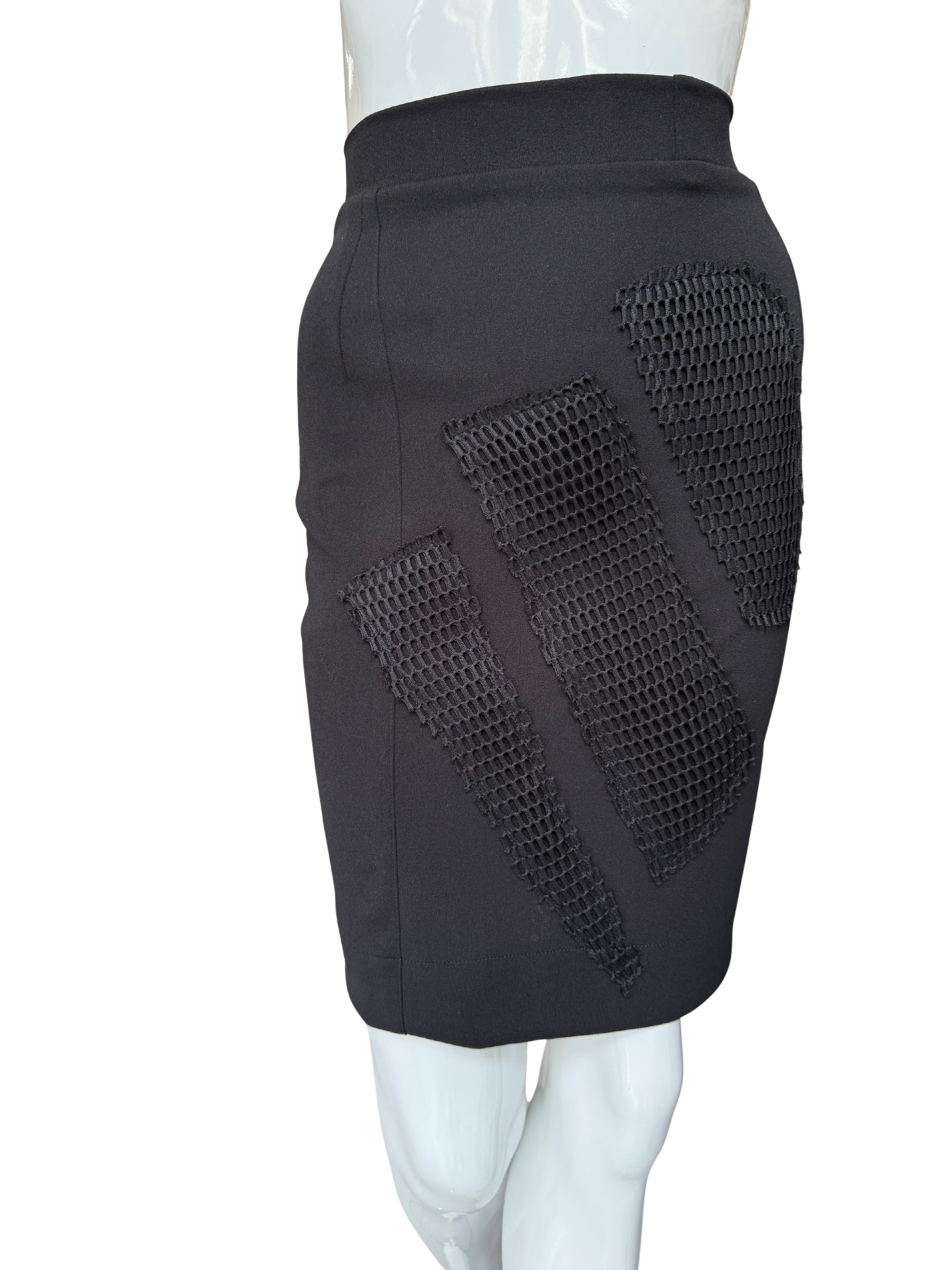 Side view of statement mesh patch pencil skirt in black showing dramatic mesh panel inserts and knee-length silhouette with modern textural contrast
