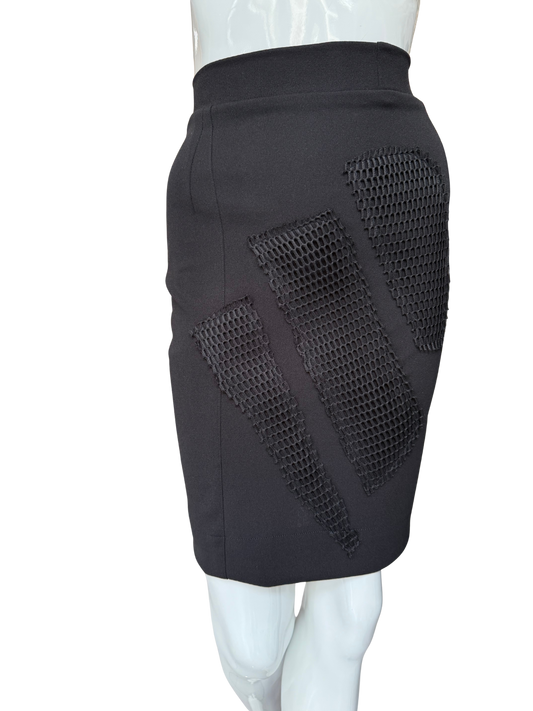 Side view of statement mesh patch pencil skirt in black showing dramatic mesh panel inserts and knee-length silhouette with modern textural contrast