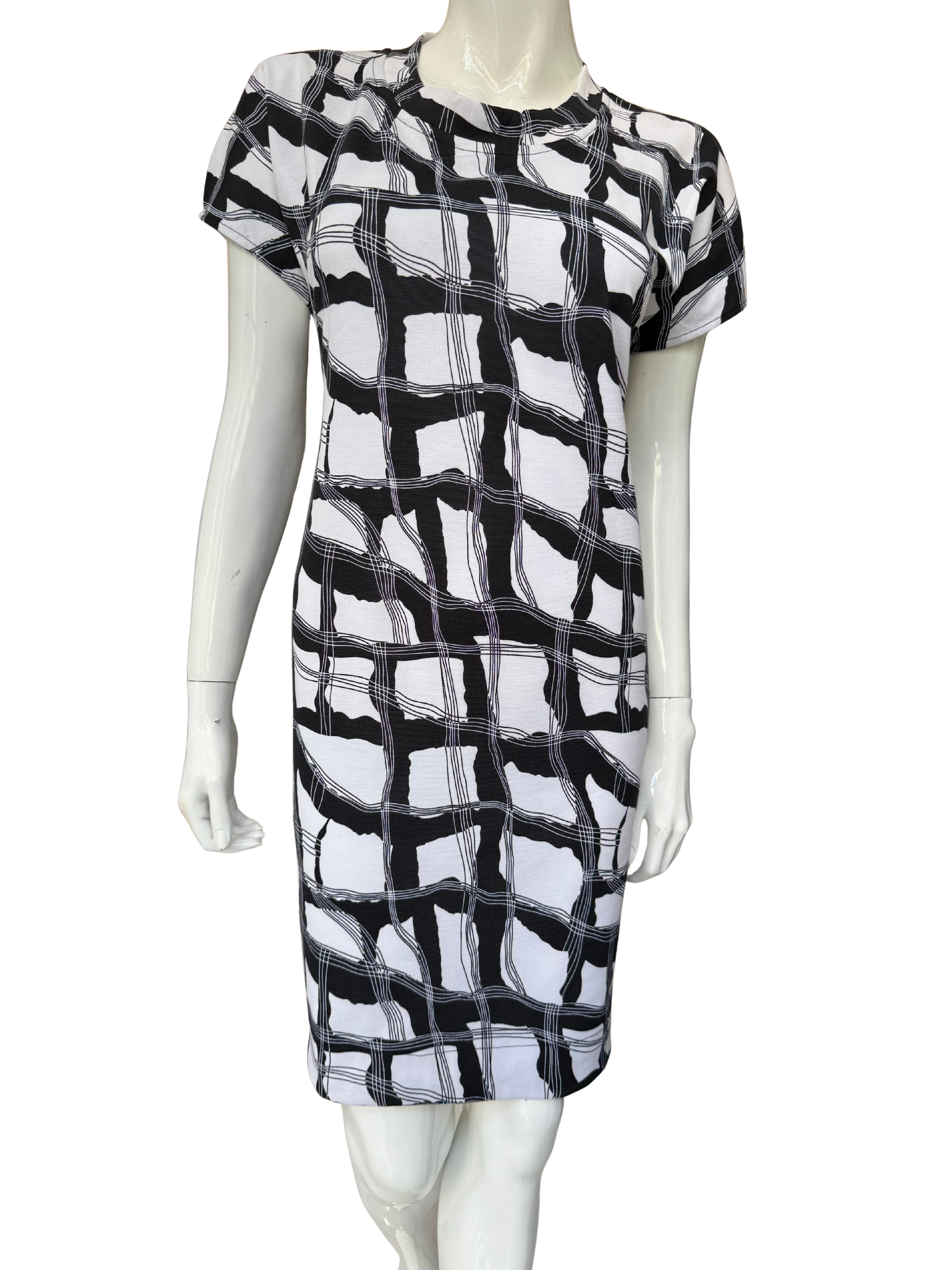 Front view of essential printed stretch crepe dress featuring bold black and white geometric pattern with cap sleeves and knee-length silhouette in comfortable fabric