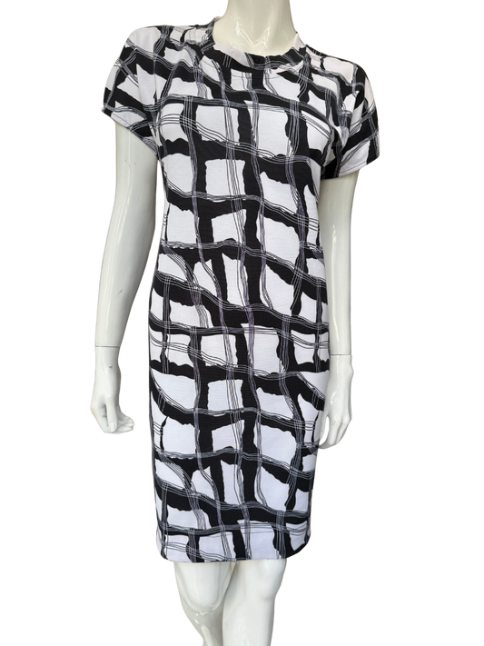 Front view of essential printed stretch crepe dress featuring bold black and white geometric pattern with cap sleeves and knee-length silhouette in comfortable fabric