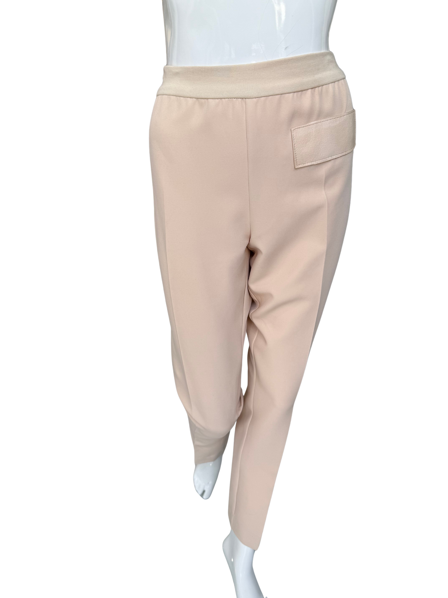 Front view of essential woven stretch crepe pants in tan featuring elastic waistband and sleek ankle-length silhouette with functional pocket detail