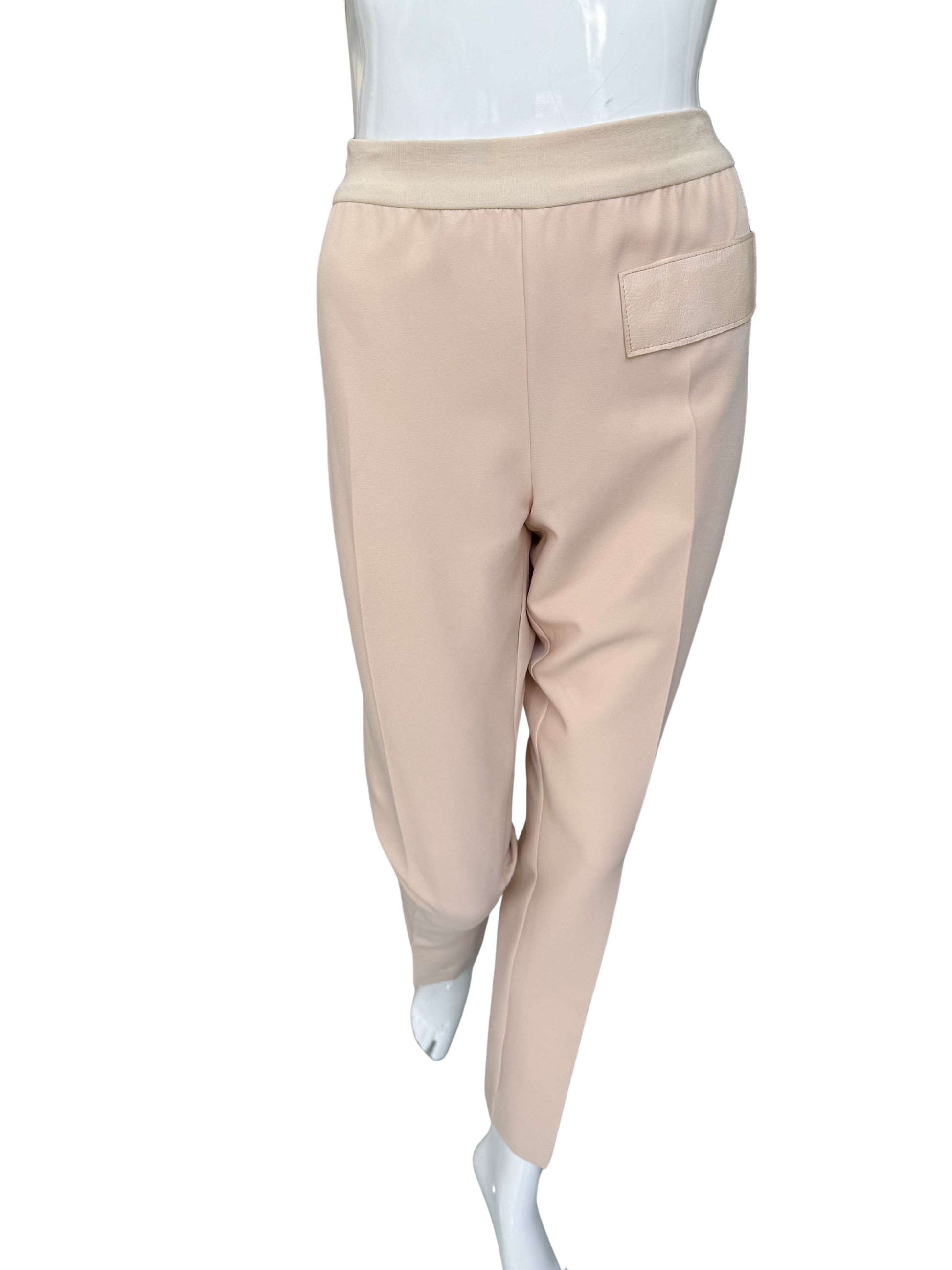 Front view of essential woven stretch crepe pants in tan featuring elastic waistband and sleek ankle-length silhouette with functional pocket detail