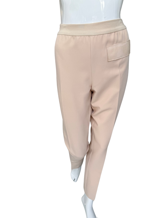 Front view of essential woven stretch crepe pants in tan featuring elastic waistband and sleek ankle-length silhouette with functional pocket detail