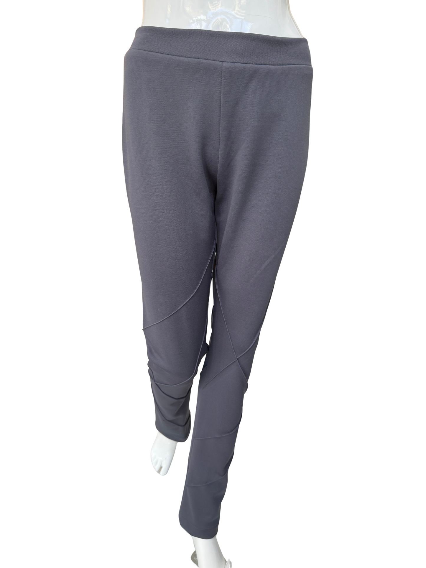Front view of contemporary knit stretch crepe pants in charcoal showing distinctive seaming details and ankle-length silhouette with modern visual interest