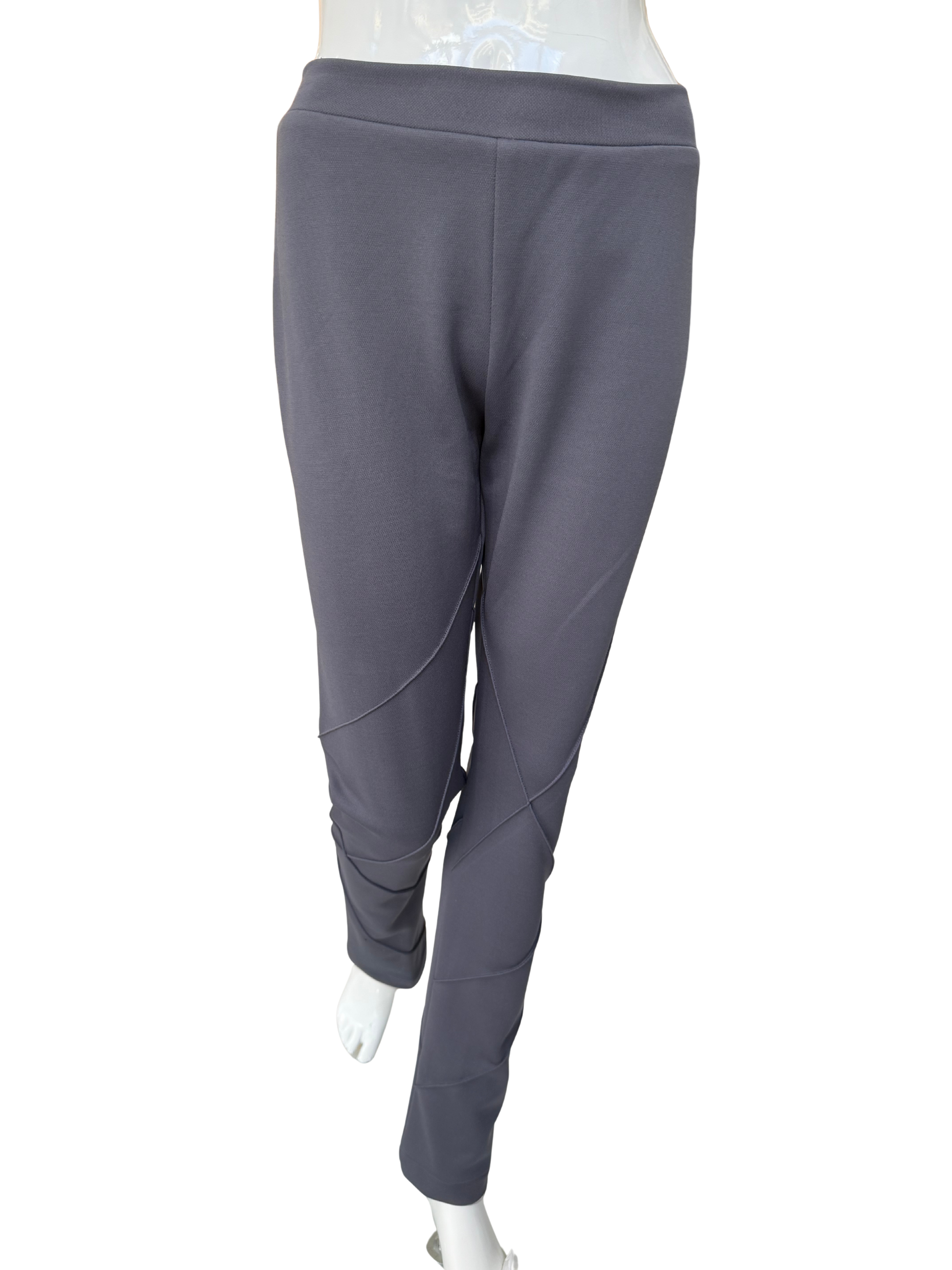 Front view of contemporary knit stretch crepe pants in charcoal showing distinctive seaming details and ankle-length silhouette with modern visual interest