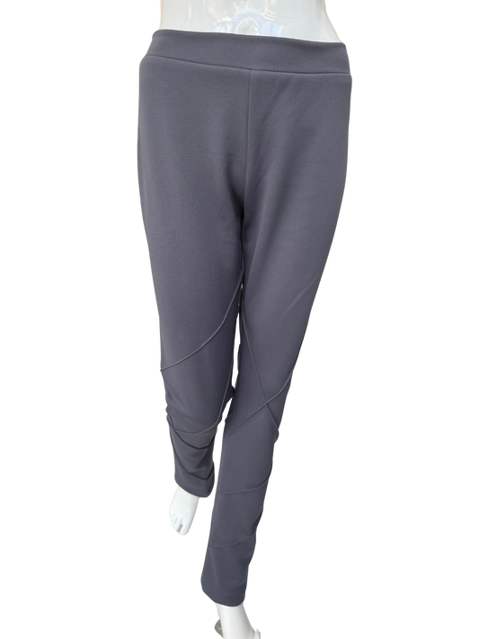 Front view of contemporary knit stretch crepe pants in charcoal showing distinctive seaming details and ankle-length silhouette with modern visual interest