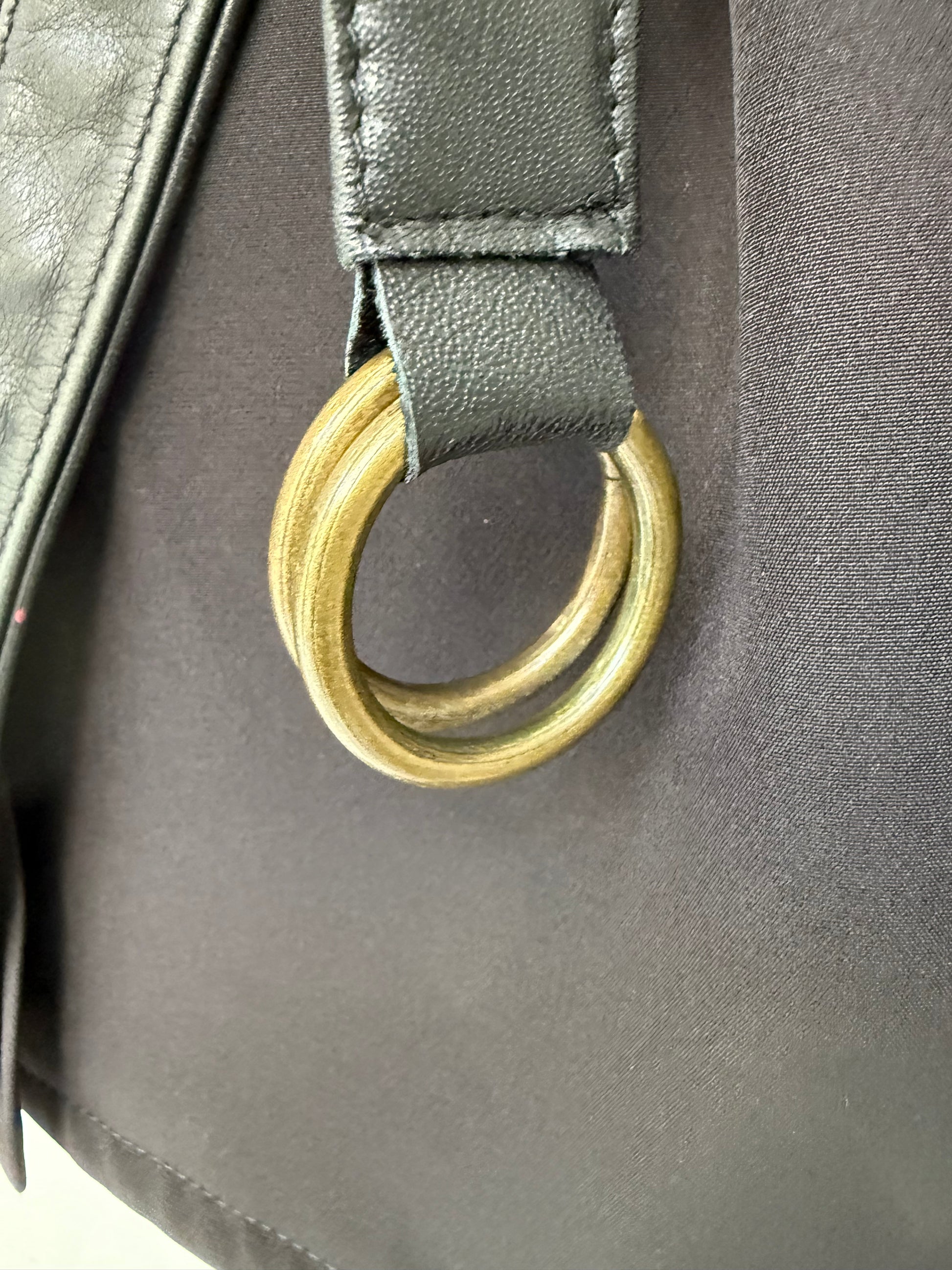 Close-up of distinctive gold-tone hardware on contemporary leather belt, highlighting quality craftsmanship and modern design details