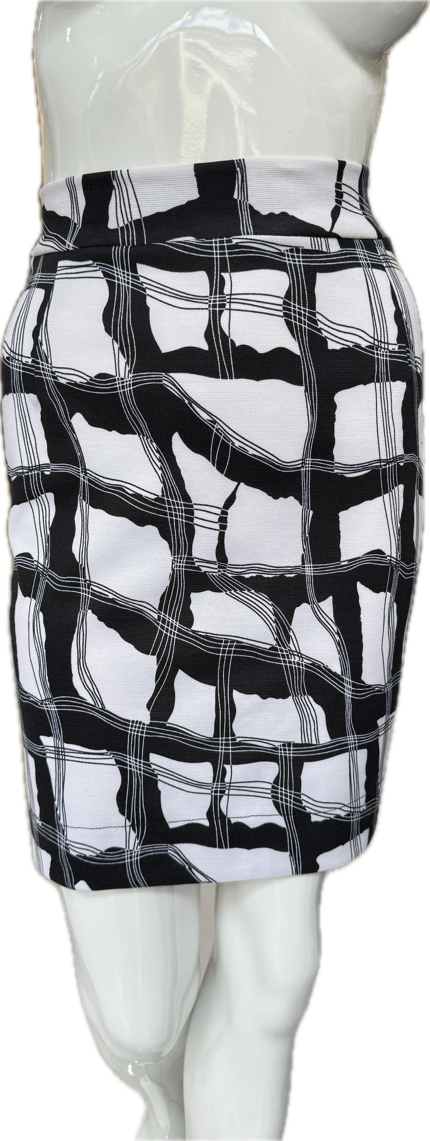 Front view of distinctive knit crepe skirt in bold black and white geometric print showing dynamic intersecting lines and knee-length cut
