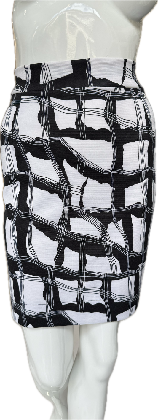 Front view of distinctive knit crepe skirt in bold black and white geometric print showing dynamic intersecting lines and knee-length cut