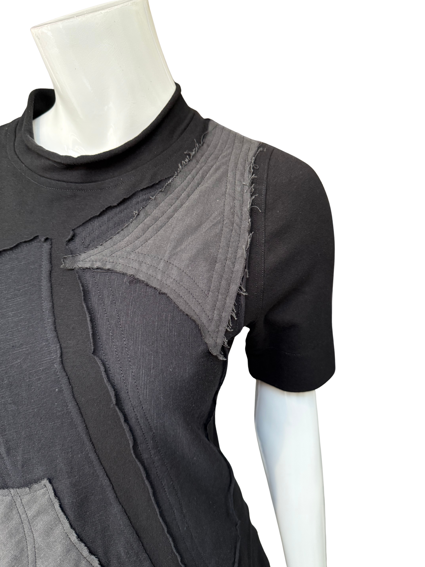 Close-up of black DeAnna Dress showing raw-edge gray patchwork details, mock turtleneck, and cotton lycra construction on mannequin