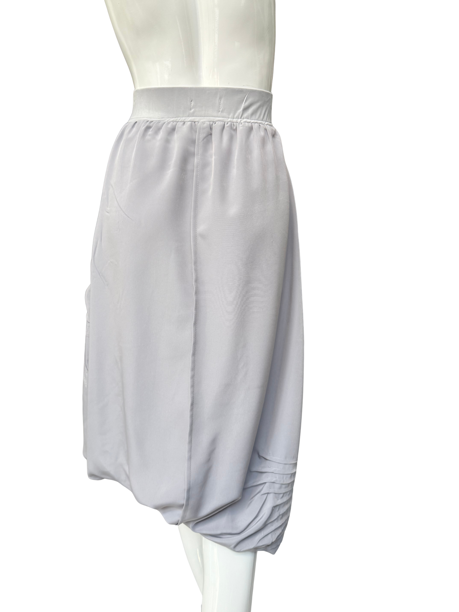 White Blaine Skirt on mannequin showing asymmetrical adjustable hemline with diagonal seam details and side pocket functionality