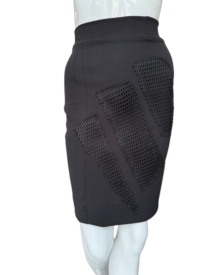 Side view of statement mesh patch pencil skirt in black showing dramatic mesh panel inserts and knee-length silhouette with modern textural contrast