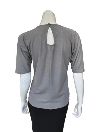 Back view of grey patch top showing keyhole detail and quality construction with sophisticated textured fabric contrasts and contemporary appeal