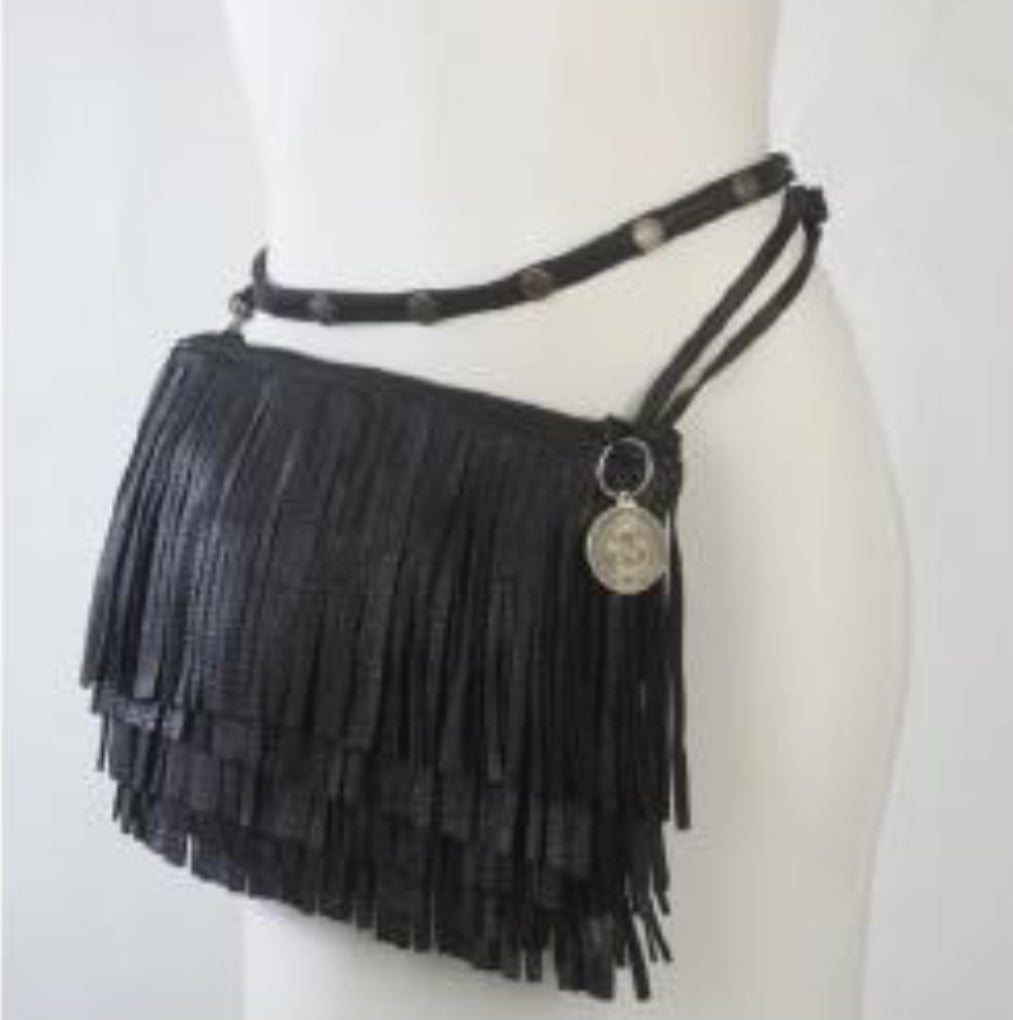 A black calf leather crossbody fringe clutch bag with multi-tiered fringe detail, adjustable strap, and polished hardware charm, displayed against neutral background.  Pictured here, worn at the hip, on a white mannequin.