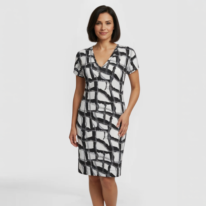 A model poses in a distinctive  black and white patterned dress, knee-length and short sleeves. Made by SWABY- A New York Fashion Designer.