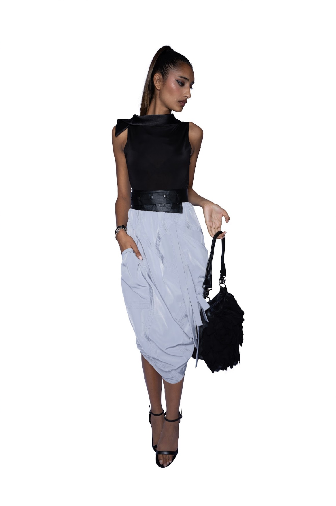 Model wearing white Blaine Skirt with black leather belt and black top, showcasing adjustable styling and sophisticated midi length with side pocket details