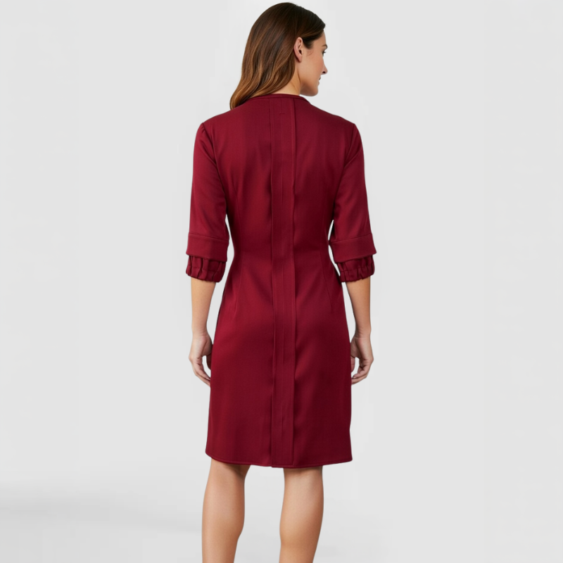 Back view of the SWABY Wendi Dress in burgundy, showing the tailored fit, vertical seaming detail down the center back, three-quarter sleeves with ruffle cuff detail, and knee-length asymmetrical hem.