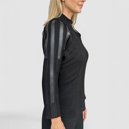 A side view of the Trinity Sweater, by SWAY - a New York Fashion Designer, shown here on a blonde fashion model featuring zip-front, hand-made surface lines and leather trim accents across the shoulder and down the length of the sleeve