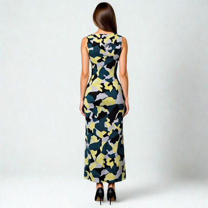 SWABY model posing, facing away from the camera, in a stunning abstract maxi dress, featuring gray, black, green and yellow designs