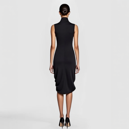 A  back view of a model posing n the Zillo Dress - a black sleeveless dress with a draped front and turtle neck collar