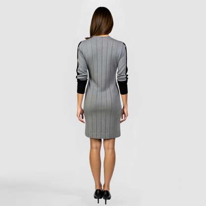 A back view of a model posing in the Zoie Jacket Dress  - a gray cardigan with black accents 