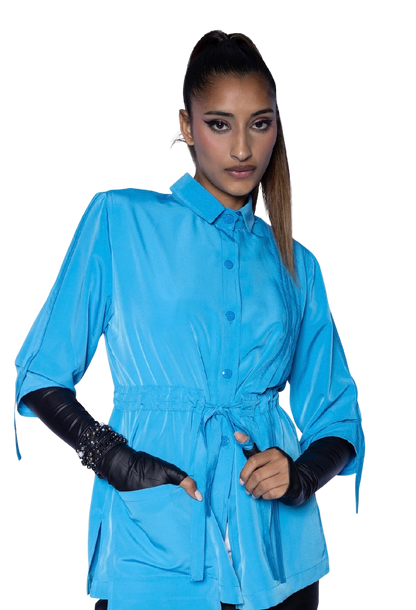 Model wearing aqua blue Molli Top drawstring blouse with black leather opera gloves, showing sophisticated styling and tailored waist silhouette