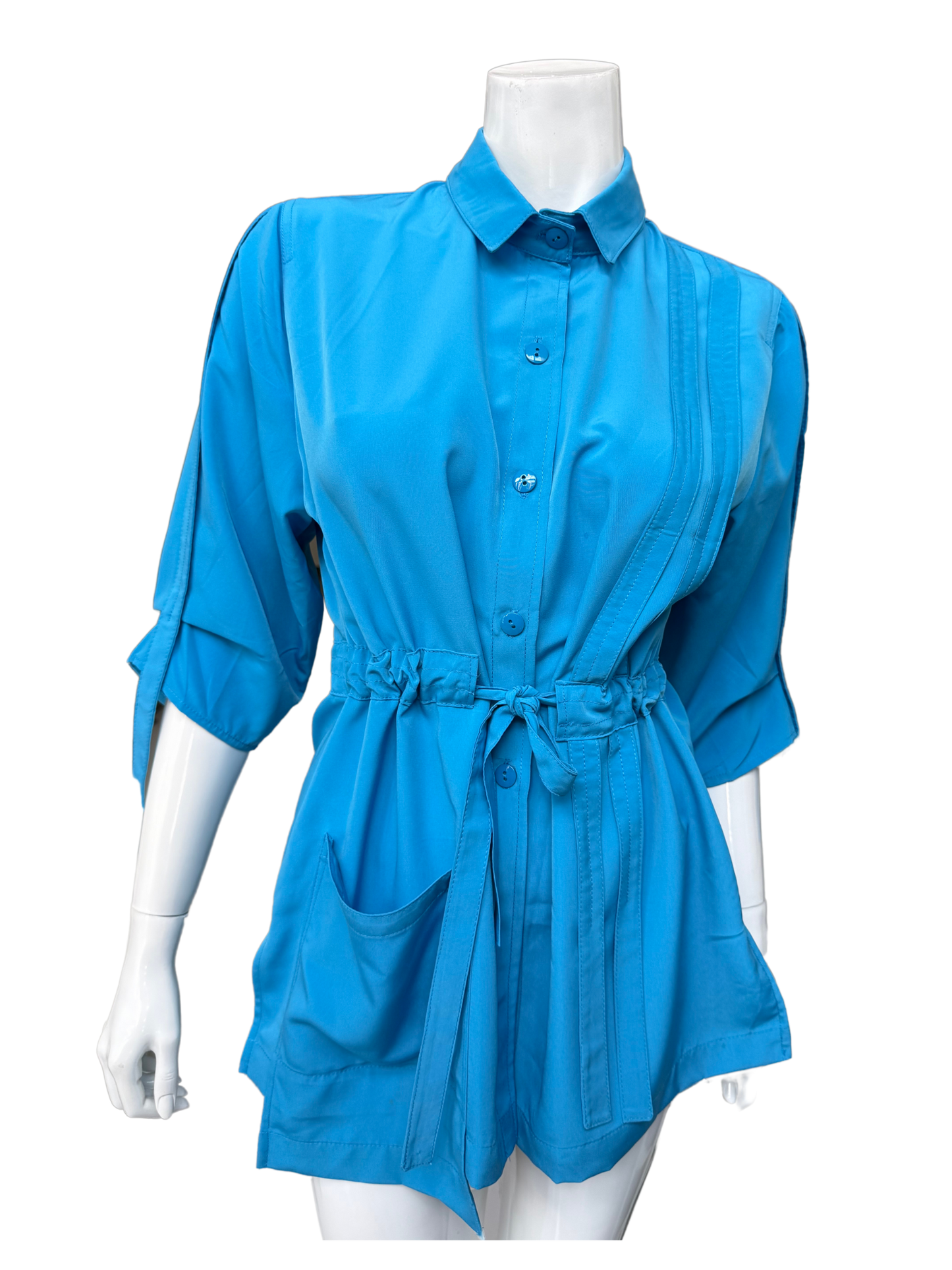 Front view of aqua blue Molli Top on mannequin showing button closure, collar detail, front pockets, and adjustable drawstring waist feature