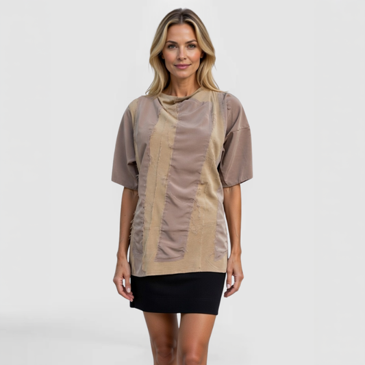 Front view of model wearing SWABY Nixxa Top in tan with contrasting patchwork panels and raw-edge stitching; relaxed fit, short sleeves, and artistic detailing for refined, wrinkle-resistant comfort and understated luxury.