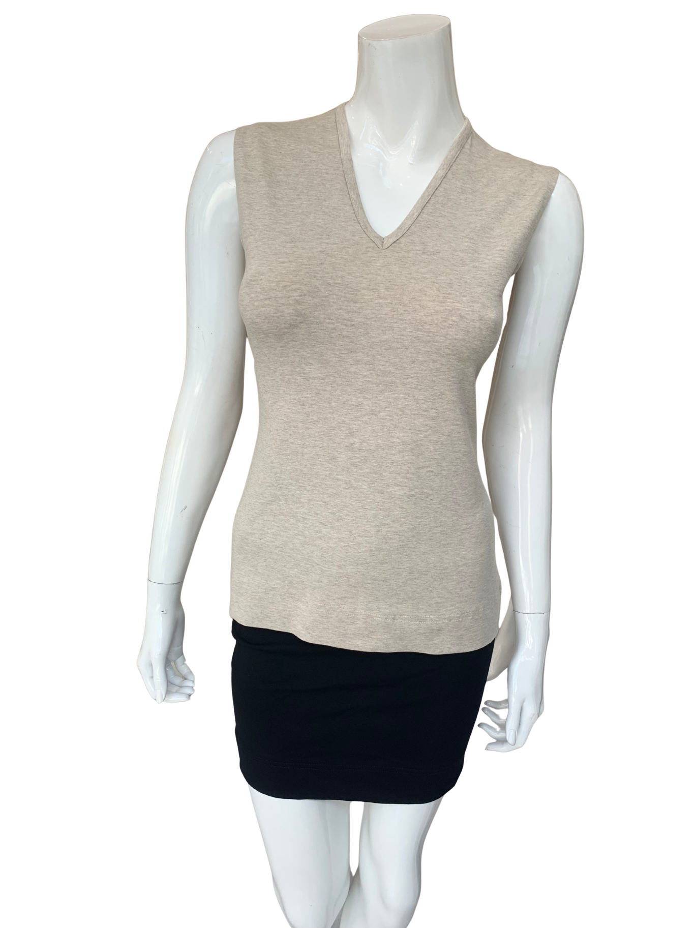 Neutral tone Shelli Top v-neck sleeveless knit top with slim fit silhouette styled with black skirt on mannequin.