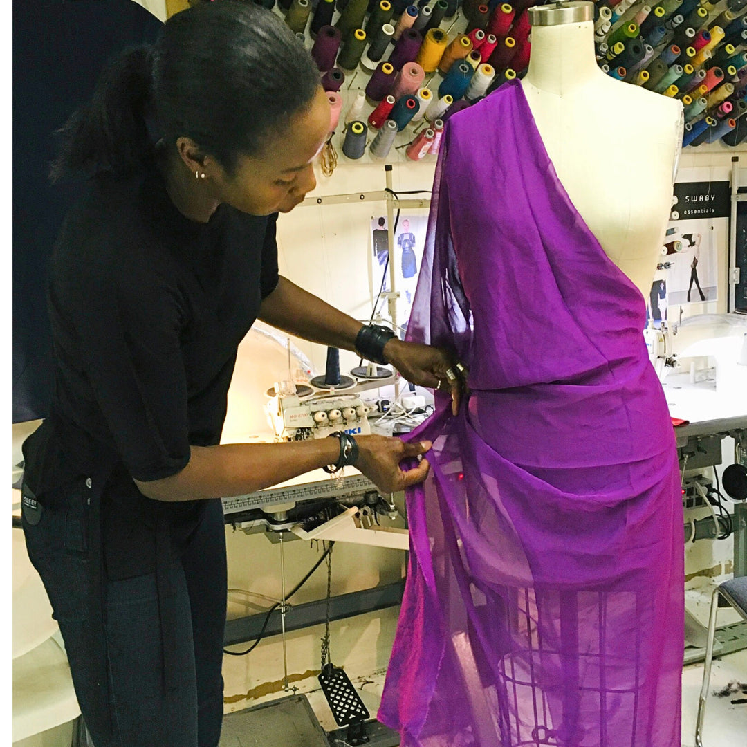 Shernett Swaby, head designer at SWABY, makes alterations to a purple dress